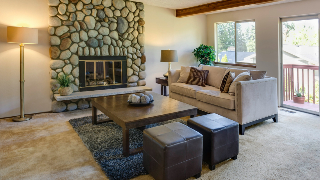 A living room with a two seater sofa and two ottomans with storage.
